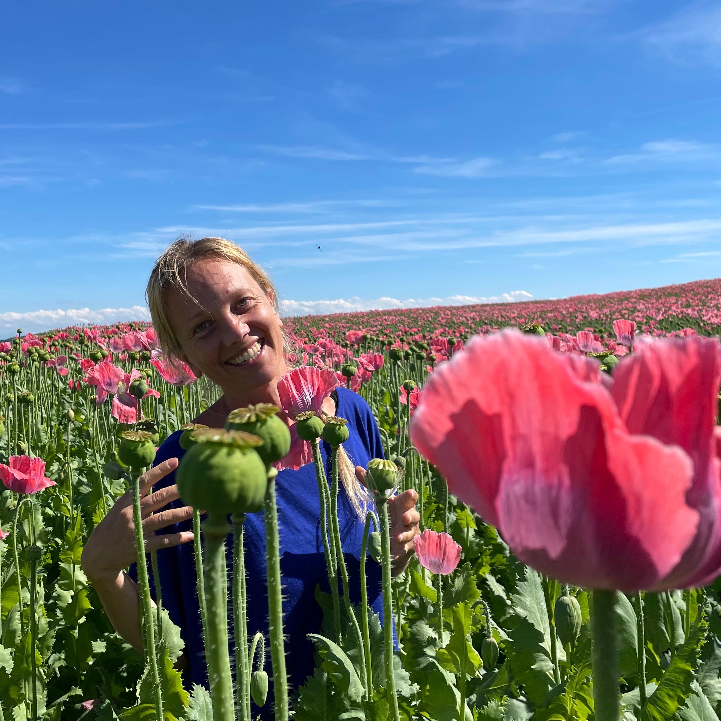 Mareike im Mohnfeld mit Blüte in der Hand